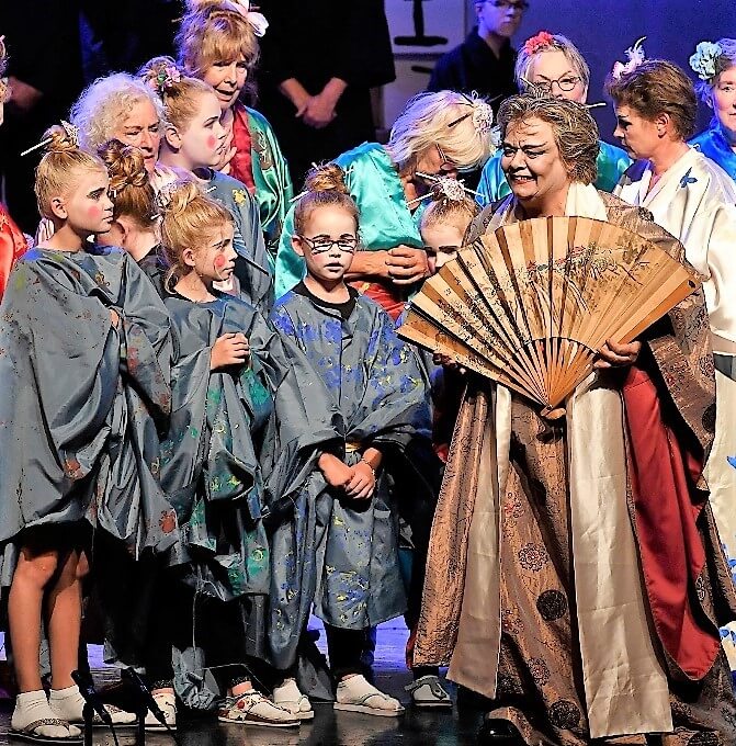 Cobien als Katisha met waaier en schoolkinderen tijdens opera